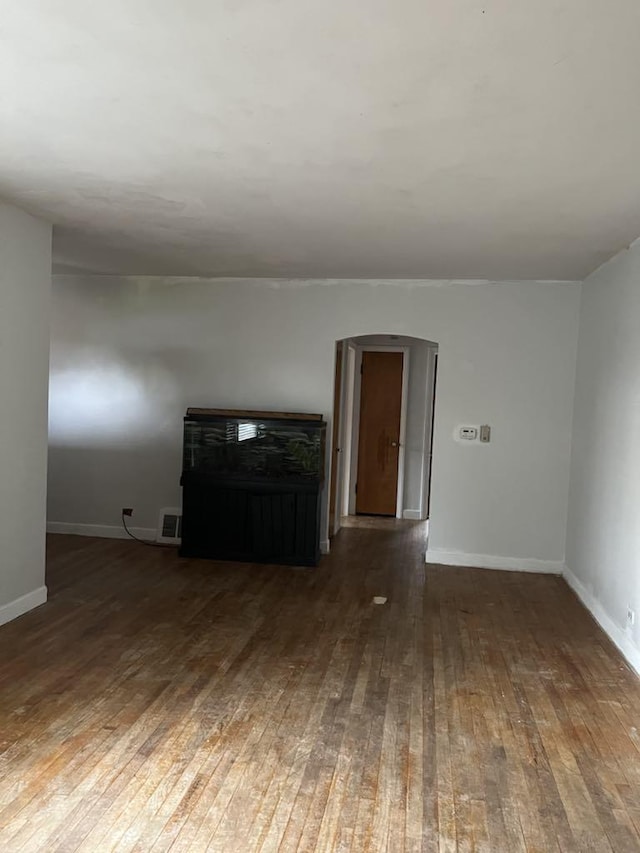 2517 S 4th Ave, North Riverside, IL 60546 - unfurnished living room featuring hardwood / wood-style flooring, baseboards, and arched walkways