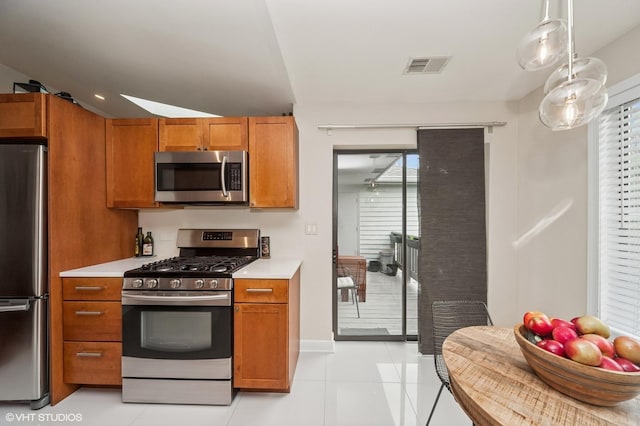 1411 W Partridge Ln Unit 4, Arlington Heights, IL 60004 - kitchen with appliances with stainless steel finishes, brown cabinetry, light countertops, and healthy amount of natural light
