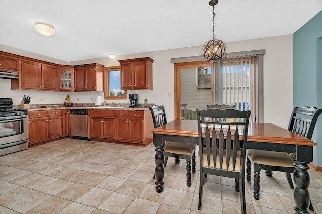 601 High Grove Dr, Minooka, IL 60447 - kitchen featuring appliances with stainless steel finishes, brown cabinetry, under cabinet range hood, a sink, and light countertops