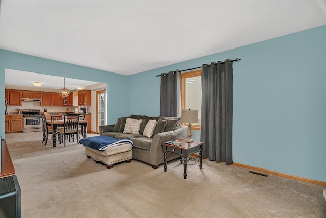 601 High Grove Dr, Minooka, IL 60447 - living area with light colored carpet, baseboards, and a chandelier
