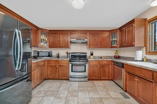 601 High Grove Dr, Minooka, IL 60447 - kitchen featuring appliances with stainless steel finishes, a sink, brown cabinetry, and under cabinet range hood