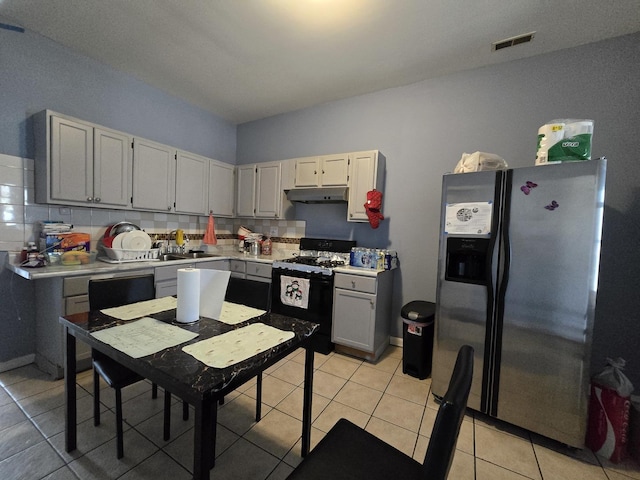 5747 S Laflin St, Chicago, IL 60636 - kitchen featuring stainless steel refrigerator with ice dispenser, gas stove, under cabinet range hood, light countertops, and a sink