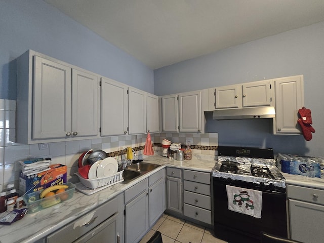 5747 S Laflin St, Chicago, IL 60636 - kitchen featuring black gas stove, under cabinet range hood, gray cabinets, and tasteful backsplash