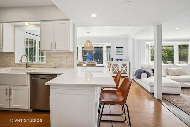 1161 Vernon Dr, Glenview, IL 60025 - kitchen with dishwasher, a sink, a kitchen breakfast bar, open floor plan, and a peninsula