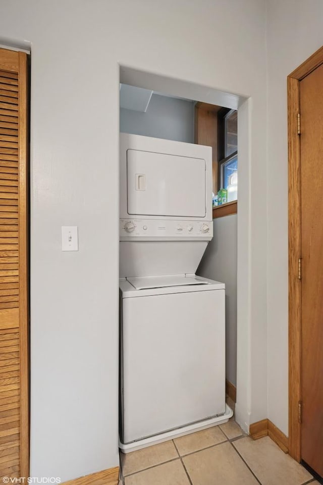 2235 N Saint Louis Ave Unit 1, Chicago, IL 60647 - laundry area with stacked washing machine and dryer, light tile patterned floors, and baseboards