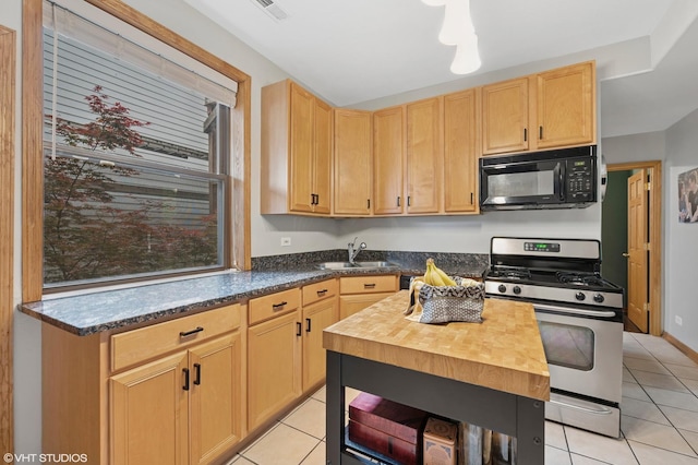 2235 N Saint Louis Ave Unit 1, Chicago, IL 60647 - kitchen with black microwave, stainless steel range with gas cooktop, a sink, and light tile patterned flooring