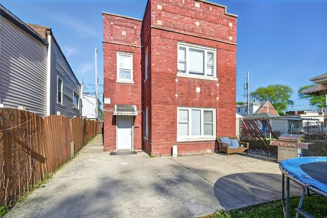 1738 N Latrobe Ave, Chicago, IL 60639 - rear view of house featuring a trampoline, brick siding, and a patio area