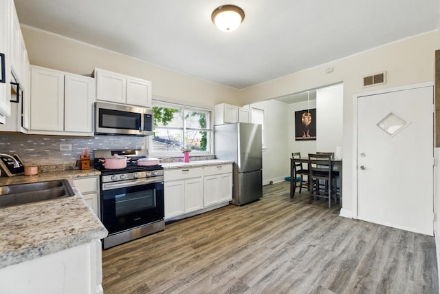 1738 N Latrobe Ave, Chicago, IL 60639 - kitchen with appliances with stainless steel finishes, a sink, white cabinetry, and light wood finished floors