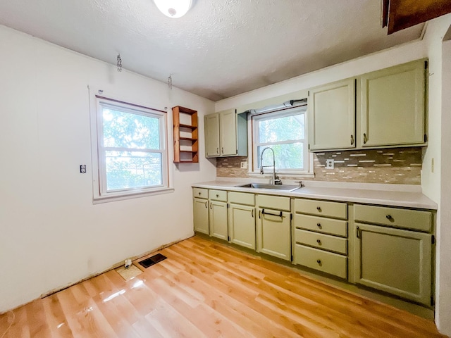 378 E Union St, Seneca, IL 61360 - kitchen with green cabinetry, decorative backsplash, light wood-style floors, light countertops, and a textured ceiling