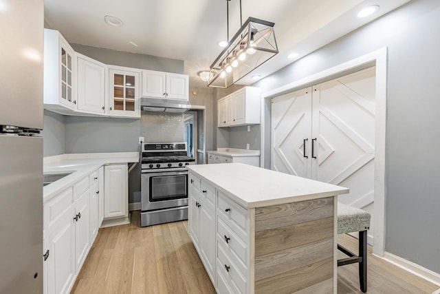 7115 S Rockwell St, Chicago, IL 60629 - kitchen with stainless steel appliances, under cabinet range hood, glass insert cabinets, light countertops, and light wood-style flooring