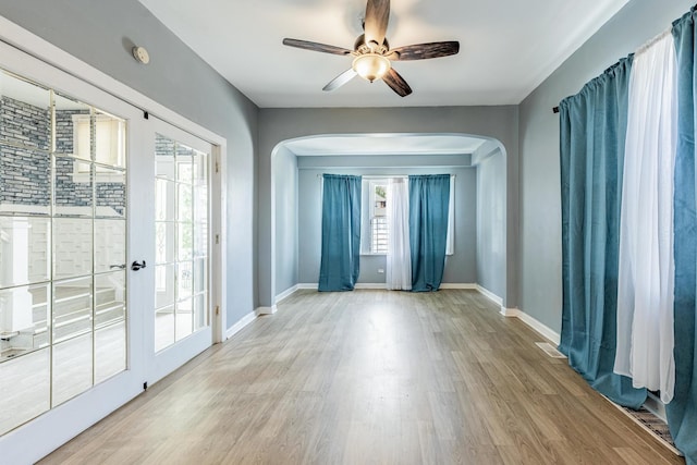 7115 S Rockwell St, Chicago, IL 60629 - spare room featuring arched walkways, wood finished floors, a ceiling fan, baseboards, and a smoke detector