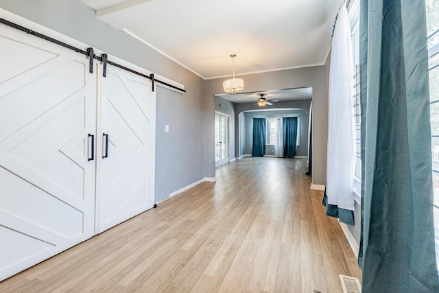 7115 S Rockwell St, Chicago, IL 60629 - foyer entrance featuring a barn door, light wood-style flooring, baseboards, ceiling fan, and crown molding
