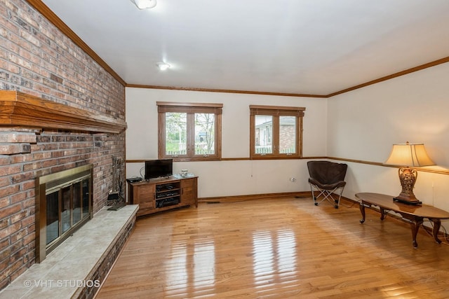 735 Vermont Rd, Frankfort, IL 60423 - living area with light wood-type flooring, a brick fireplace, crown molding, and baseboards