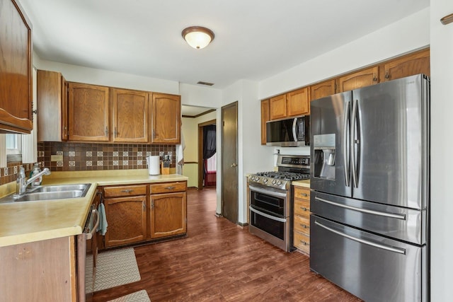 143 Hesterman Dr, Glendale Heights, IL 60139 - kitchen with stainless steel appliances, a sink, light countertops, tasteful backsplash, and brown cabinets