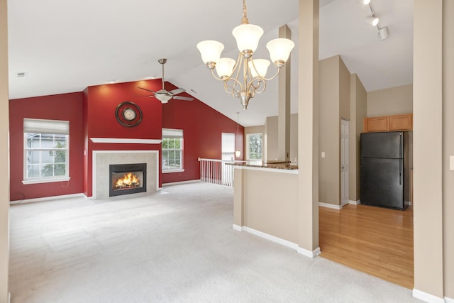 2422 Georgetown Cir, Aurora, IL 60503 - unfurnished living room with ceiling fan, light colored carpet, high vaulted ceiling, baseboards, and a chandelier