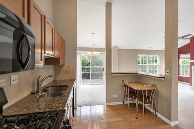 2422 Georgetown Cir, Aurora, IL 60503 - kitchen featuring black appliances, brown cabinets, a chandelier, a sink, and light wood-style floors