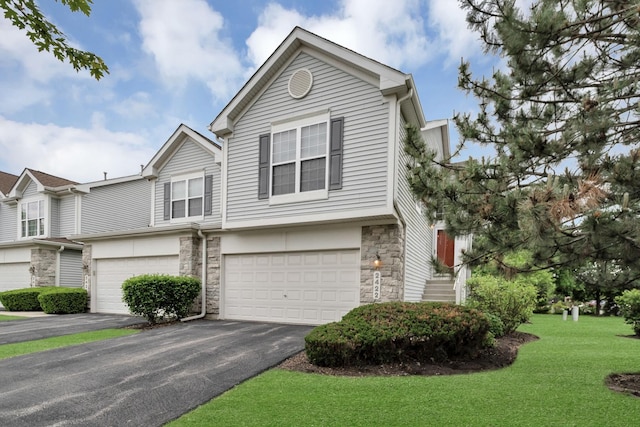 2422 Georgetown Cir, Aurora, IL 60503 - view of front facade featuring stone siding, an attached garage, asphalt driveway, and a front lawn