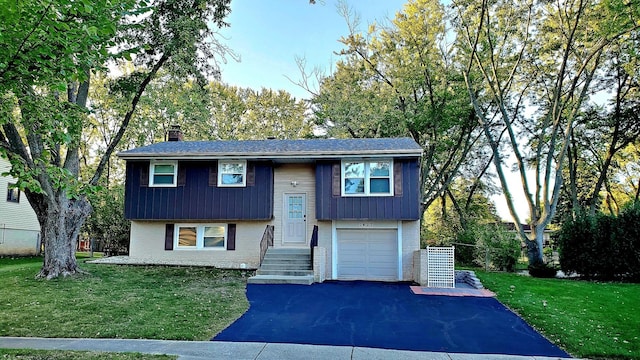 1427 Hampton Ln, Schaumburg, IL 60193 - bi-level home with brick siding, a chimney, driveway, a garage, and a front yard