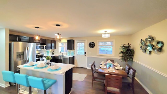 1427 Hampton Ln, Schaumburg, IL 60193 - kitchen with stainless steel appliances, light countertops, decorative light fixtures, a center island, and a sink