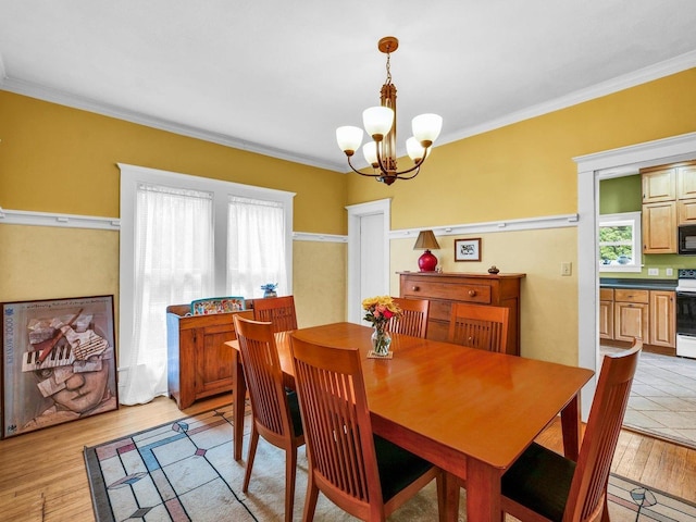 611 S Lynn St, Champaign, IL 61820 - dining area with a chandelier, light wood finished floors, and crown molding