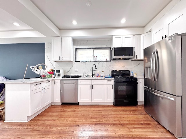 3316 W Flournoy St, Chicago, IL 60624 - kitchen with appliances with stainless steel finishes, a sink, a peninsula, white cabinetry, and recessed lighting