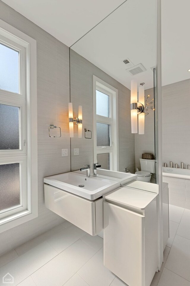 1807 W Ohio St, Chicago, IL 60622 - bathroom with tile patterned floors, tile walls, tiled tub, vanity, and toilet