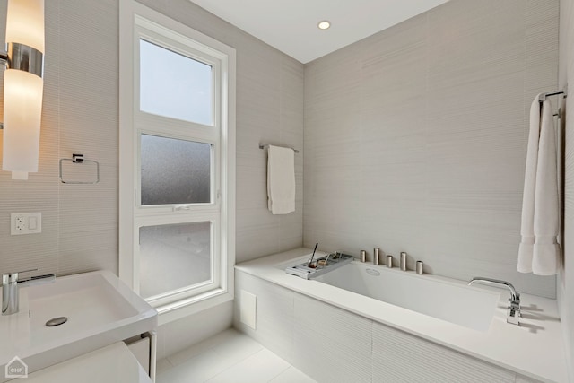 1807 W Ohio St, Chicago, IL 60622 - bathroom featuring tile walls, a garden tub, a sink, and tile patterned floors