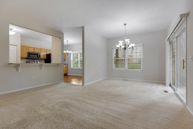 5261 Pebble Ln, Crystal Lake, IL 60012 - unfurnished living room with a chandelier, light carpet, and baseboards