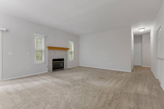 5261 Pebble Ln, Crystal Lake, IL 60012 - unfurnished living room with light colored carpet, a tiled fireplace, and baseboards
