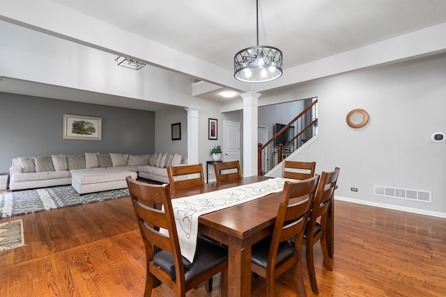 24723 W Champion Dr, Plainfield, IL 60585 - dining space with decorative columns, wood finished floors, a chandelier, and baseboards
