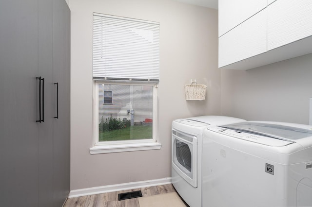 24723 W Champion Dr, Plainfield, IL 60585 - laundry area featuring separate washer and dryer, light wood-type flooring, cabinet space, and baseboards