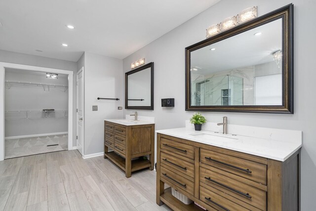 24723 W Champion Dr, Plainfield, IL 60585 - bathroom featuring a marble finish shower, two vanities, wood finished floors, a walk in closet, and recessed lighting