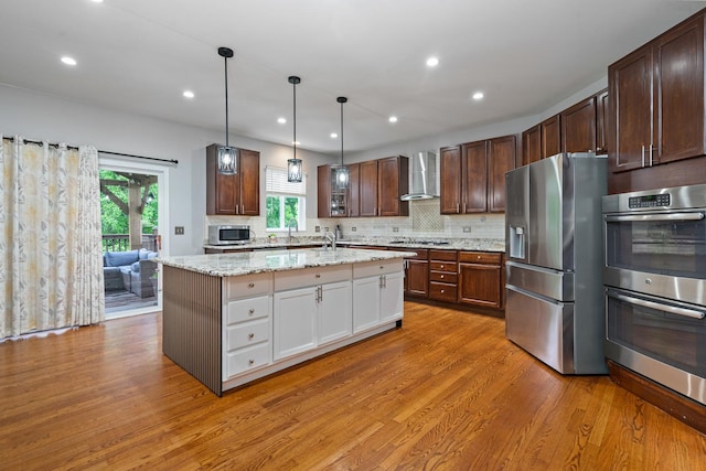 24723 W Champion Dr, Plainfield, IL 60585 - kitchen with appliances with stainless steel finishes, wall chimney range hood, light wood-type flooring, a sink, and backsplash