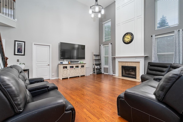 24723 W Champion Dr, Plainfield, IL 60585 - living room with a towering ceiling, a tiled fireplace, wood finished floors, baseboards, and plenty of natural light