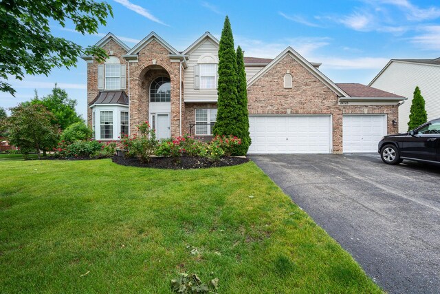 24723 W Champion Dr, Plainfield, IL 60585 - traditional-style house with asphalt driveway, a front yard, brick siding, and an attached garage