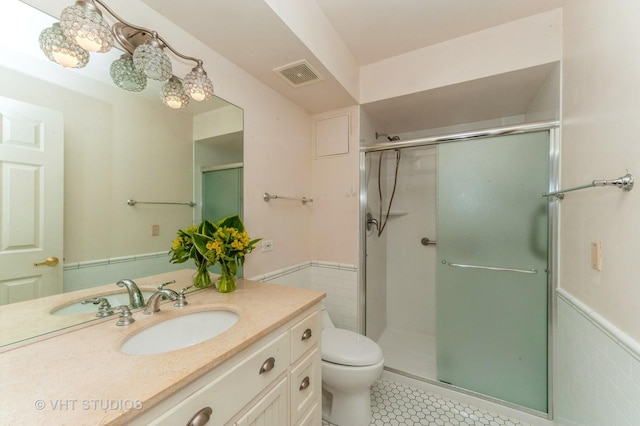 1220 Depot St Unit 411, Glenview, IL 60025 - full bathroom featuring wainscoting, vanity, a shower stall, toilet, and tile walls