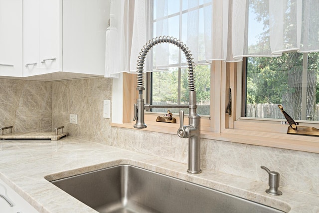 14240 W Forest Dr, Lake Forest, IL 60045 - kitchen view of a sink, white cabinets, and backsplash