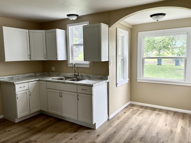 105 W 2nd St, Spring Valley, IL 61362 - kitchen featuring a sink, arched walkways, light wood-style flooring, and healthy amount of natural light