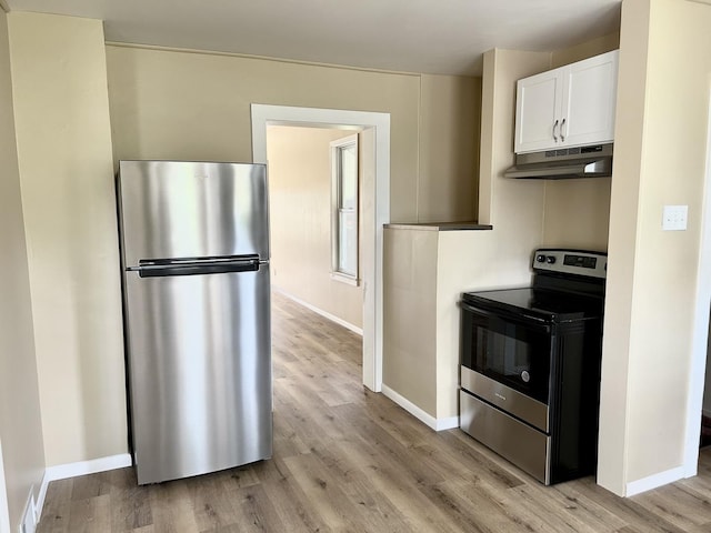 105 W 2nd St, Spring Valley, IL 61362 - kitchen featuring appliances with stainless steel finishes, under cabinet range hood, light wood-type flooring, baseboards, and white cabinetry