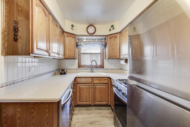266 S Warrington Rd, Des Plaines, IL 60016 - kitchen with appliances with stainless steel finishes, a sink, light wood-style floors, brown cabinets, and tasteful backsplash