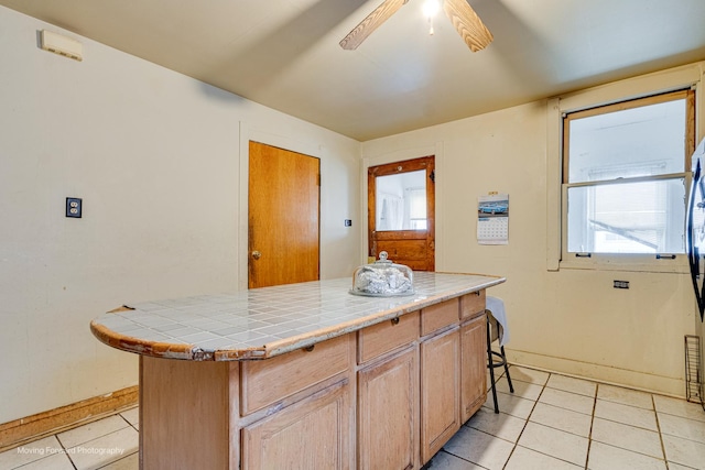 1508 N Massasoit Ave, Chicago, IL 60651 - kitchen with tile countertops, light tile patterned flooring, ceiling fan, and a kitchen island