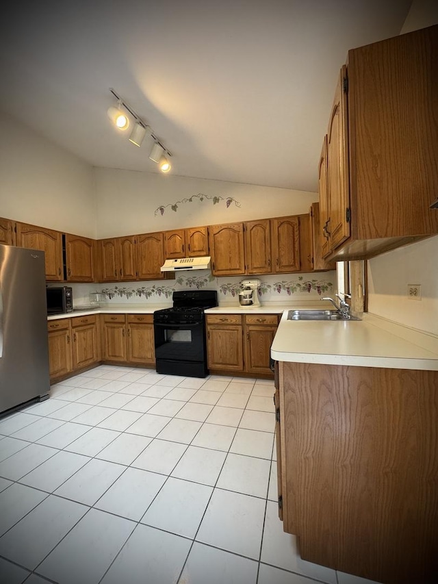 3006 Hawthorne Ln, Hazel Crest, IL 60429 - kitchen with black appliances, brown cabinetry, track lighting, under cabinet range hood, and vaulted ceiling