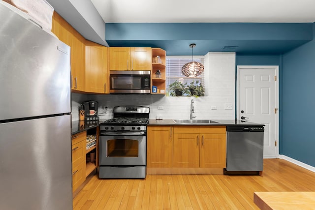 5054 N Troy St Unit 3, Chicago, IL 60625 - kitchen featuring stainless steel appliances, a sink, light wood-type flooring, decorative backsplash, and dark countertops