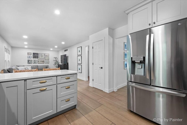 2552 Autumn Grove Ct, Aurora, IL 60504 - kitchen featuring stainless steel fridge with ice dispenser, open floor plan, light wood-type flooring, recessed lighting, and light countertops