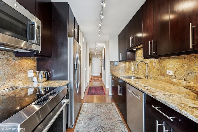 71 E Division St Unit 1606, Chicago, IL 60610 - kitchen featuring appliances with stainless steel finishes, wood finished floors, light stone counters, a sink, and decorative backsplash