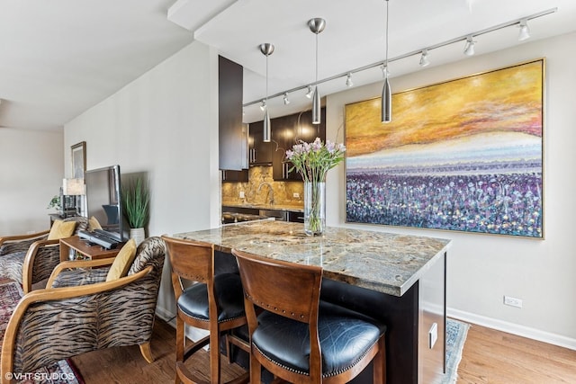 71 E Division St Unit 1606, Chicago, IL 60610 - kitchen featuring rail lighting, light wood-style flooring, and a breakfast bar area