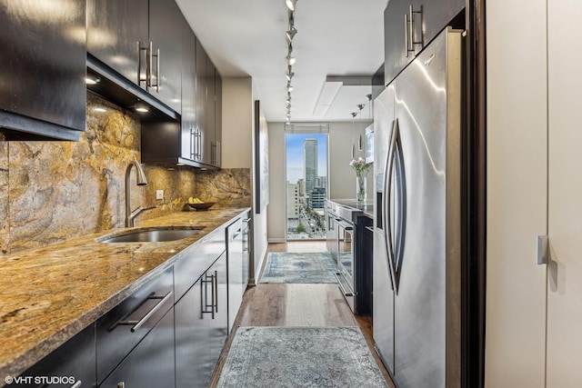 71 E Division St Unit 1606, Chicago, IL 60610 - kitchen with a sink, stainless steel appliances, dark wood-type flooring, rail lighting, and tasteful backsplash