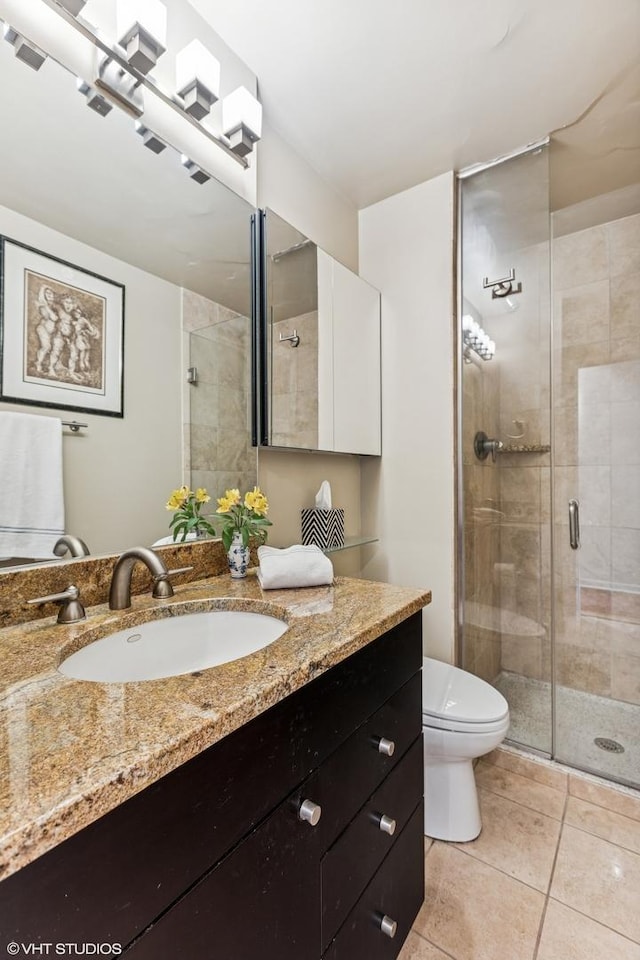 71 E Division St Unit 1606, Chicago, IL 60610 - bathroom with vanity, toilet, a stall shower, and tile patterned floors
