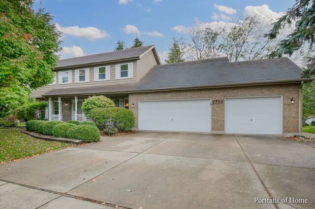 2755 Newport Dr, Naperville, IL 60565 - view of front facade with driveway, an attached garage, brick siding, covered porch, and roof with shingles
