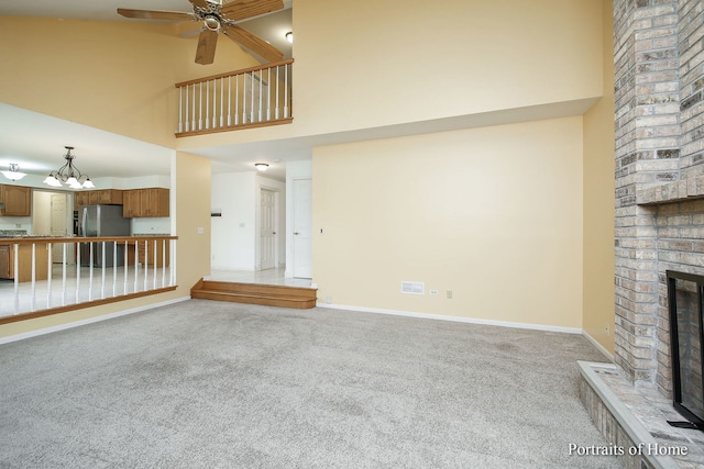 2755 Newport Dr, Naperville, IL 60565 - unfurnished living room with a towering ceiling, light carpet, ceiling fan, a fireplace, and a chandelier